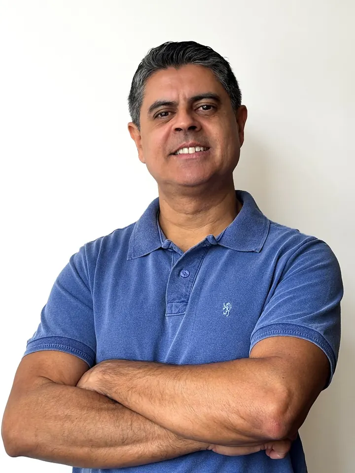 Handerson de Sousa, de braços cruzados, sorrindo